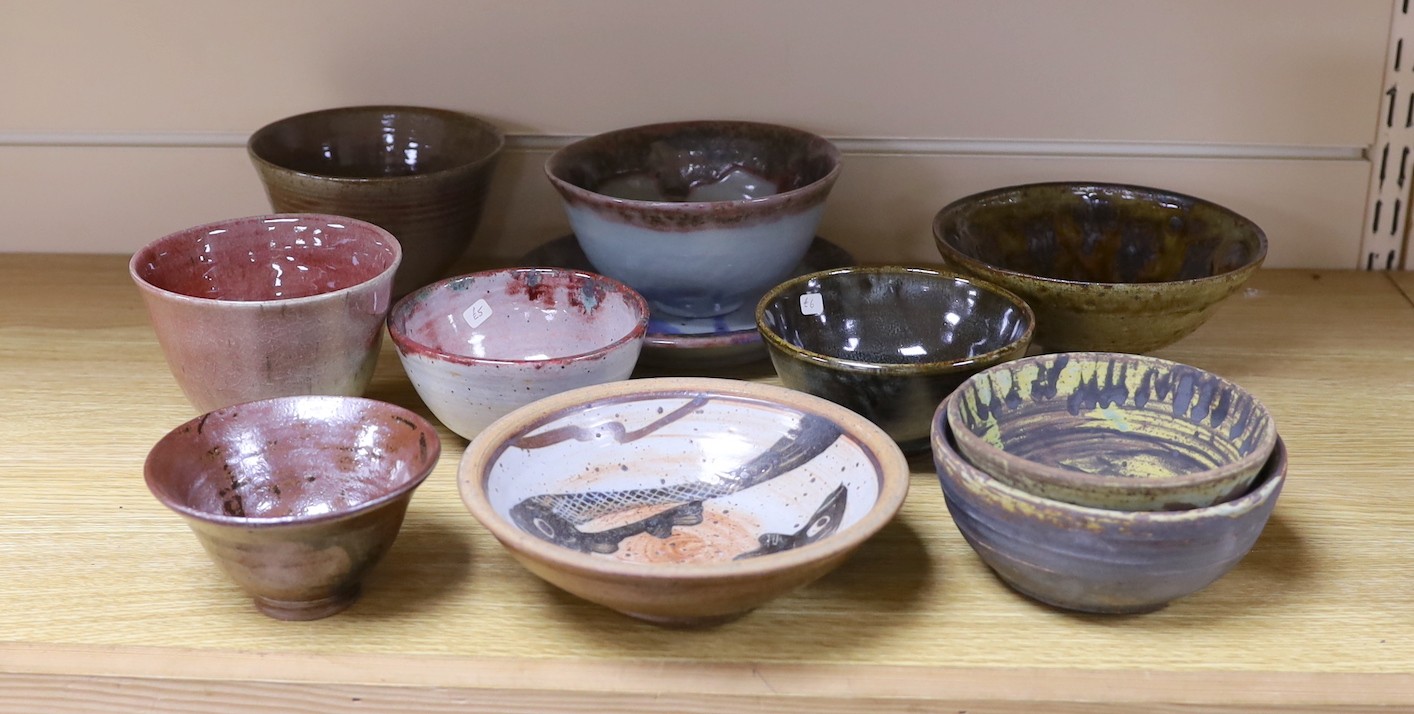 A large pottery figural tile together with a collection of studio pottery bowls